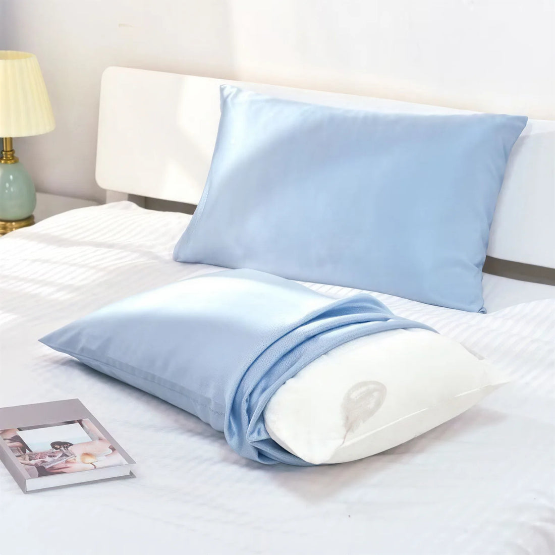 Light-blue silk pillowcase styled on a bed