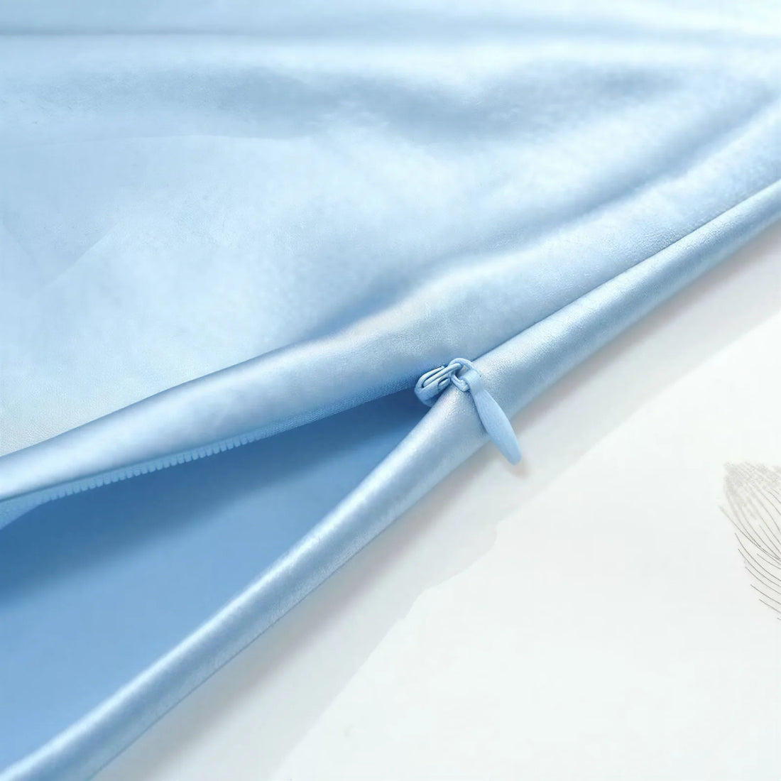 Close-up of light-blue silk fabric and a hidden zipper