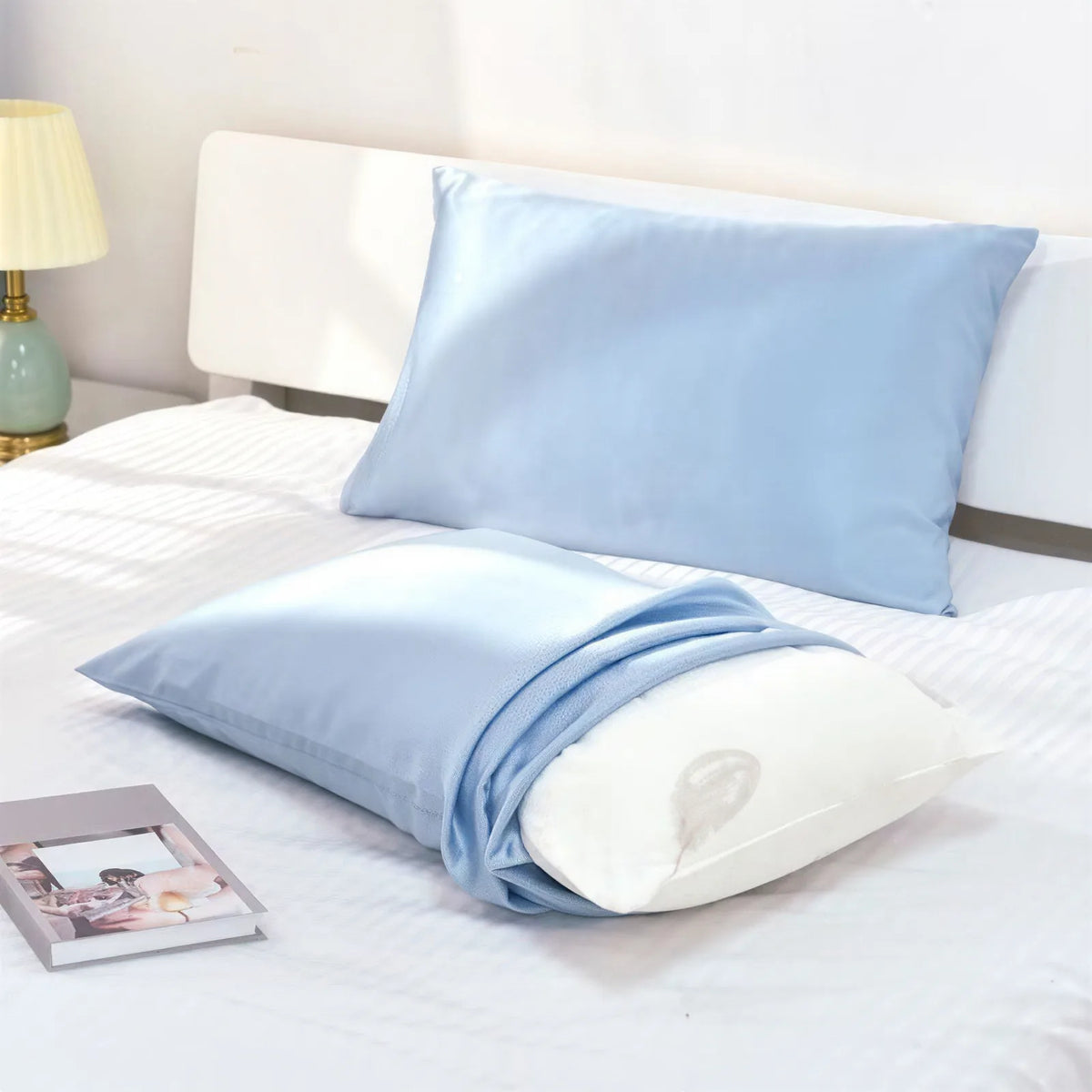 Light-blue silk pillowcase styled on a bed